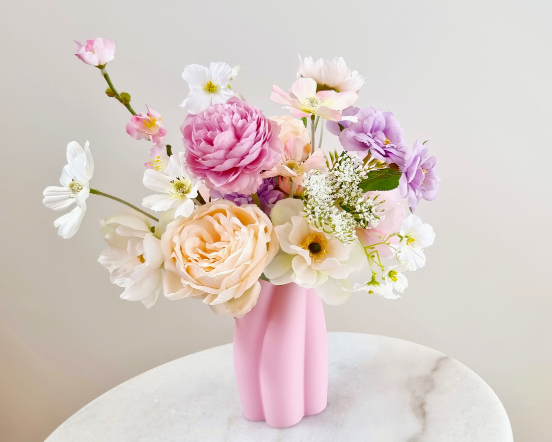 Heather flowers bouquet in pink vase on white table