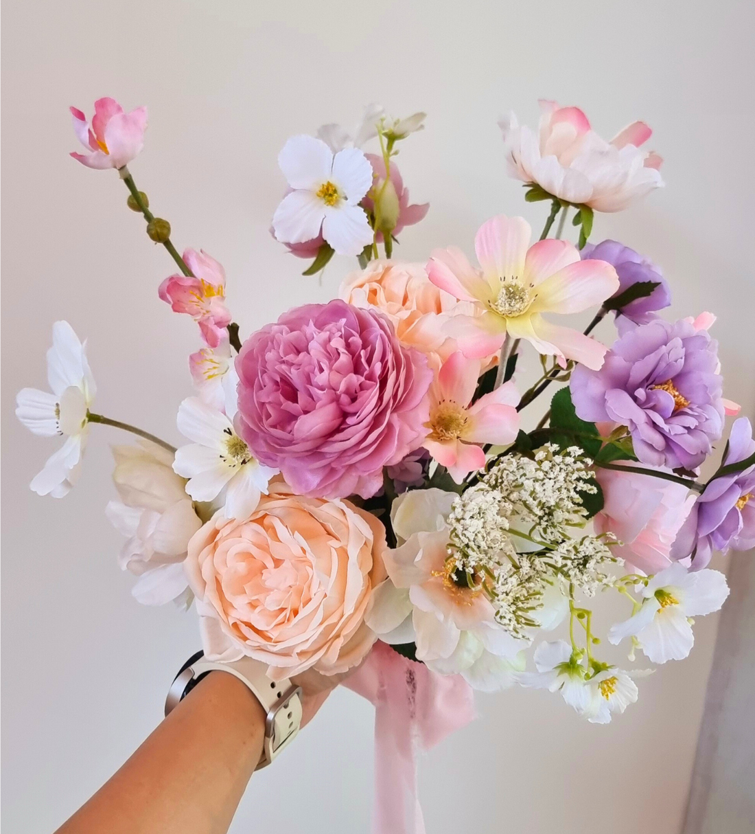 Heather flowers bouquet in pink vase on white table